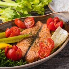 Delicious salmon fillet baked with tomatoes and stern celery. Diet food concept. Closeup