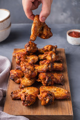 Hand holds chicken wing