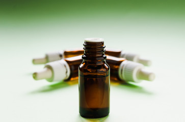 cosmetology, skin care, glass bottles with pipettes and hyaluronic acid inside on a green background