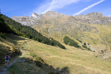 Fototapeta na wymiar Hiker following a trail in the Pyrenees mountains