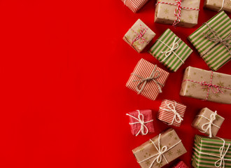 Christmas presents gifts on a red background. Simple, classic red and white wrapped gift boxes with ribbon bows and holiday decorations. Horizontal lower bound.