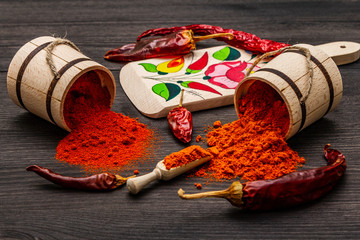 Magyar (Hungarian) red sweet and hot paprika powder. Traditional pattern on a cutting board,...