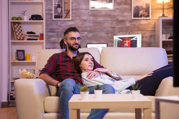 Beautiful young couple watching their favorite tv show