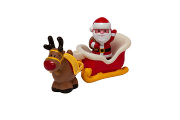 Children's toy - Santa Claus with a bag of gifts rides in a sleigh pulled by a deer isolated on white