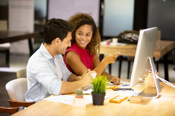 Working together on project. Two young business colleagues working on computer