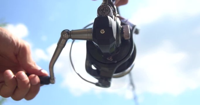 fisherman with fish rod trying to catch carp. Gear coil movement.