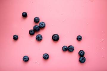 Flat lay composition with tasty blueberry and space for text on color pink background.