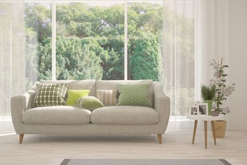 Stylish room in white color with sofa and summer landscape in window. Scandinavian interior design. 3D illustration