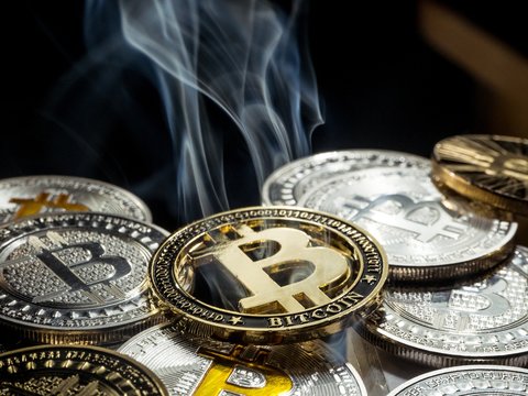 Golden crypto currency Bitcoin coin smoke out laying between other coins