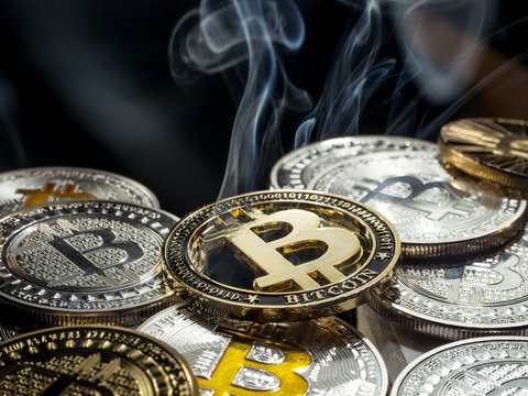 Golden crypto currency Bitcoin coin smoke out laying between other coins