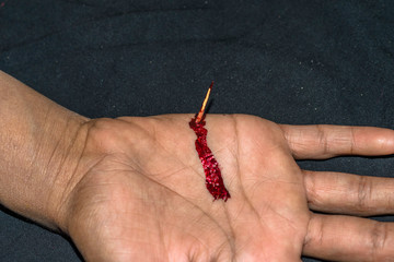 sharp thorn dipped into a human hand and it's bleeding 