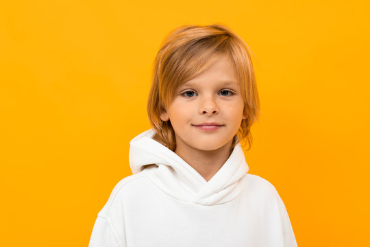 portrait of blond boy grimacing on yellow studio background close-up