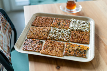 Turkish Homemade Snacks Biscuit with Sunflower Seeds, Sesame and Dill /Crispy Yaprak Galeta with Traditional Tea on Tray.