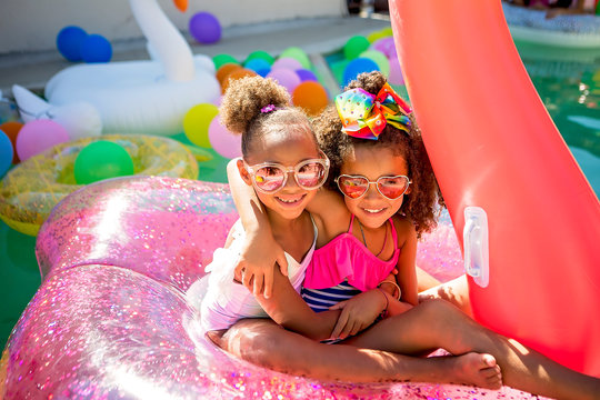 Summer fun cute little girls on inflatable flamingo