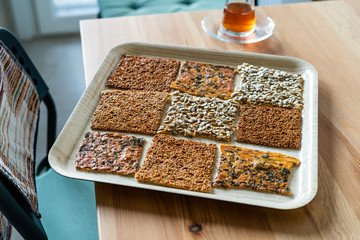 Turkish Homemade Snacks Biscuit with Sunflower Seeds, Sesame and Dill /Crispy Yaprak Galeta with Traditional Tea on Tray.