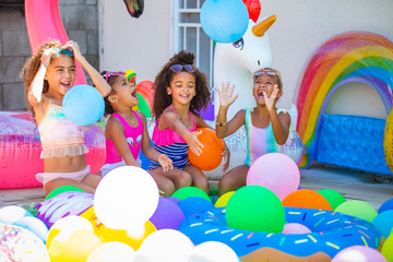 Summer pool party cute girls in sunglasses playing with balloons