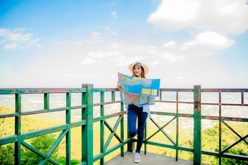 An Asian woman is traveling to see the breathtaking view in the morning with a map of the viewpoint of Wat Phra That Doi Suthep, Chiang Mai, Thailand.