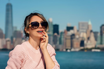 Woman in pink sweater posing on the background of New York city