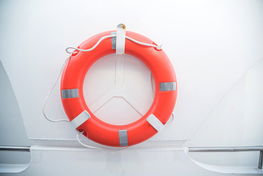 An Orange Life Buoy For Safety At Sea Attached To The Cruise Ship On White Background And Copy Space.