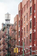 Brick buildings and water tank between Little Italy's Mulberry and Broome Streets, Manhattan, New York City. Taken on September the 26th, 2019