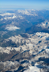 Aerial view above snow mountain peaks