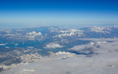 Aerial view above snow mountain peaks