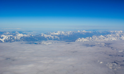 Fototapeta premium Aerial view above snow mountain peaks