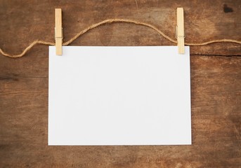 Wood clip with white paper note on wood background. 