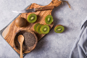 Fresh and juicy kiwi fruit and a half on cutting board.  sweet and sour taste and have high vitamin c and antioxidant.