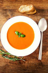 Vegetarian autumn pumpkin carrot  cream soup  on wooden table. Top view. Copy space.
