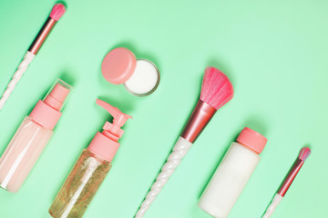 Care cosmetics in bottles on a delicate green background.