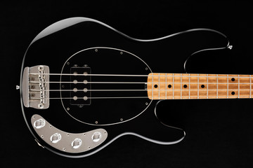 Plakat Body of a black electric bass guitar on black background