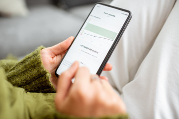 Woman checking online her medical analisys with a smartphone, close-up on a phone screen. Concept...