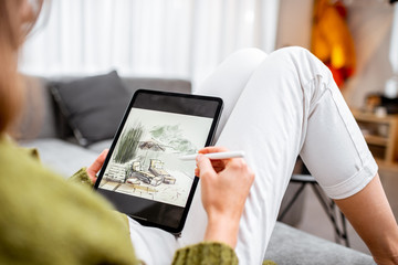 Artist or designer making landscape design, drawing on a digital tablet with pencil, close-up on a screen. Designing on a digital touchpad concept