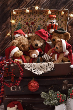 stack of old suitcases with the top one full of teddy bears in Santa caps
