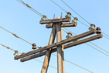 Cable electricity on wooden poles against the blue sky on a sunny day