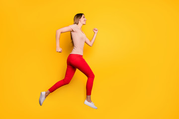 Fototapeta na wymiar Full length profile photo of funky lady jumping high rushing discount shopping store addicted person wear casual striped t-shirt red trousers isolated yellow color background