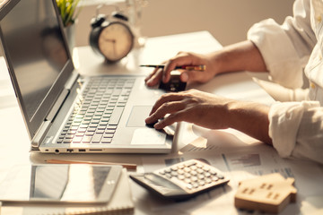 Hand of Business people calculating interest, taxes and profits to invest in real estate and home buying