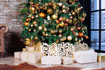 Interior with couch and Decorated Christmas tree in gold and yellow colors. Merry Christmas and Happy New Year!