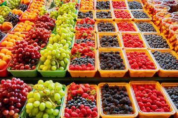 Fresh berries and fruits at display on the farmers market stall