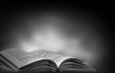 Imagine a picture book of an ancient book opened on a wooden table with a sparkling golden background. With magical power, magic, lightning around a glowing glowing book In the room of darkness