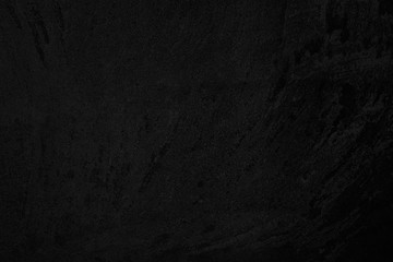 Black low contrast concrete textured wall background with roughness and irregularities to your concept or product.