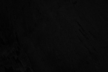 Black low contrast concrete textured wall background with roughness and irregularities to your concept or product.
