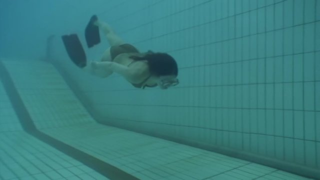 Underwater model mermaid costume in swimming pool. Young woman freediver swims in undine water nymph costume with monofiin.