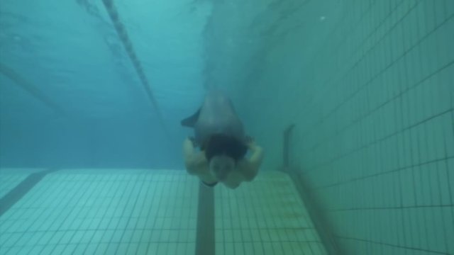 Underwater model mermaid costume in swimming pool. Young woman freediver swims in undine water nymph costume with monofiin.