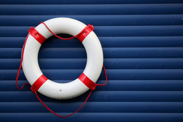Rescue ring as a maritime symbol of salvation and hope hangs on a blue wall, also as template