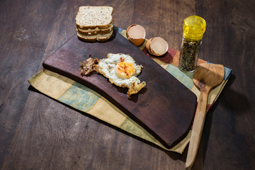 Spiced scrambled fried eggs on wooden board