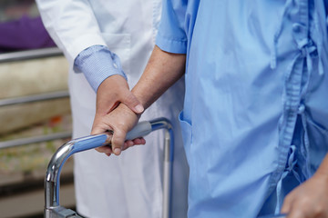 Doctor help and care Asian senior or elderly old lady woman use walker with strong health while...
