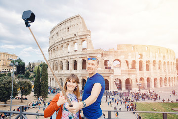 Happy young couple lover making selfie and smile Colosseum in Rome, Italy. Concept travel