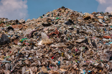 The mountain of plastic waste from urban communities and industrial districts and the blue sky